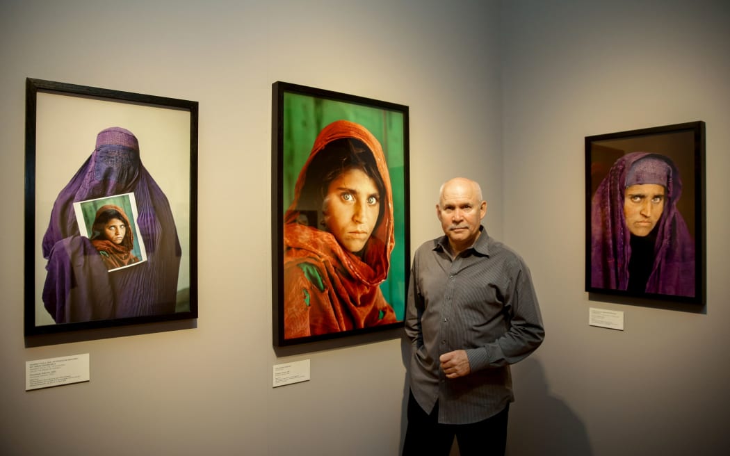 Photographer Steve McCurry with the picture he took of Sharbat Gula, who he tracked down again 17 years later. Museum of Arts and Crafts, Hamburg, Germany, 2013.