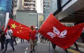 Members of a pro-Beijing and pro-police group hold large China national flag and Hong Kong SAR flag in Tsim Sha Tsui, Hong Kong, on September 18, 2019.