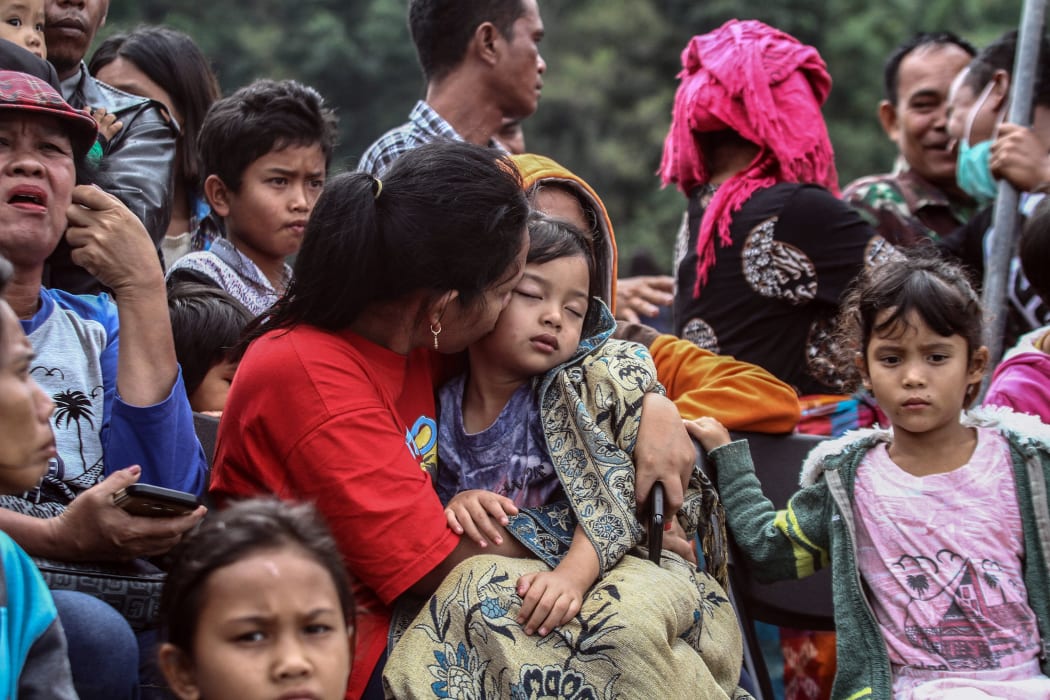 Family members gather as they wait for rescue teams searching for missing passengers at the Lake Toba ferry port in the province of North Sumatra.