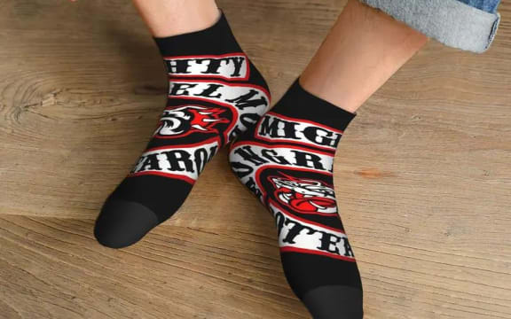 An edited image of a pair of socks featuring the logo of the Mongrel Mob being sold on Temu.