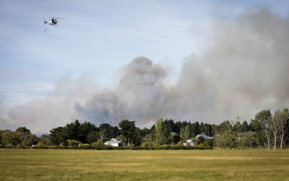 Fire nears a house at Pine Beach, just north of Christchurch.