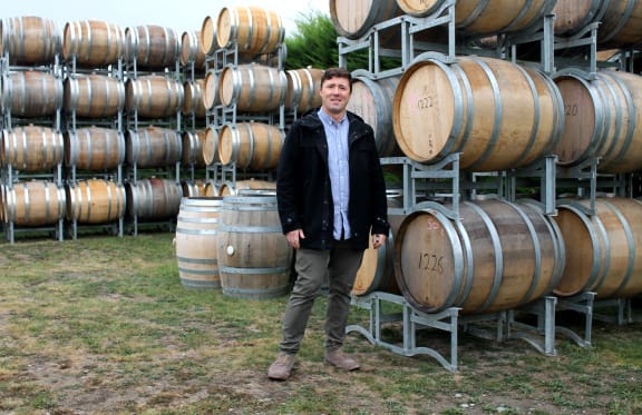 Nik Mavromatis of Muddy Water vineyard beside $1000 French oak barrels.