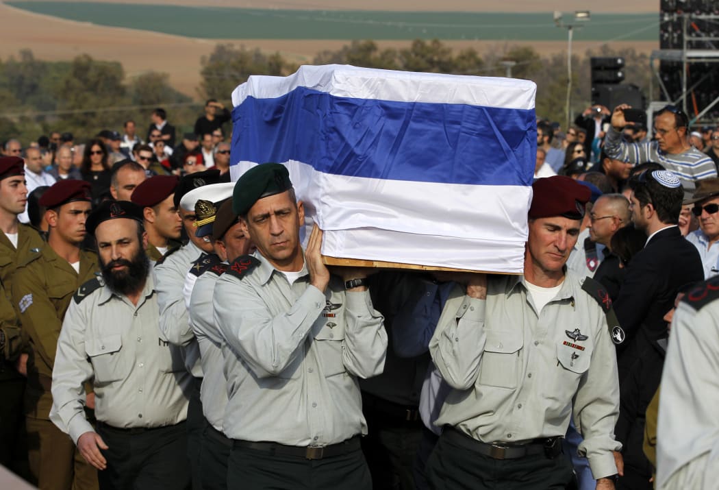Army officers carry the coffin of Ariel Sharon to his grave in southern Israel.