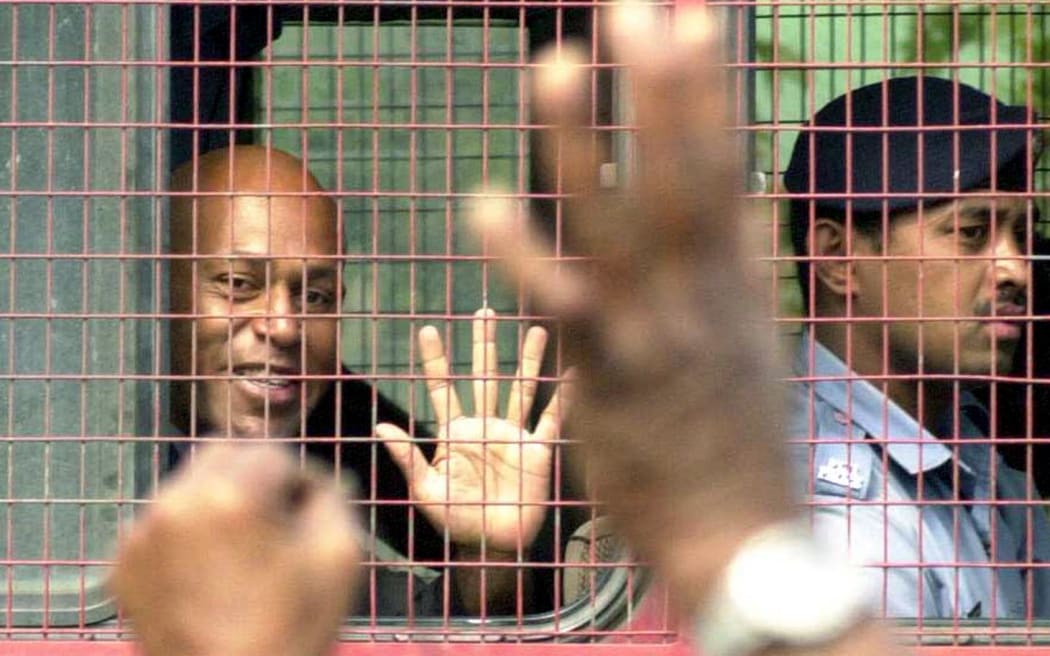 Jailed Fiji coup plotter George Speight waves to supporters as he leaves the court in Suva 05 September 2001. Speight inched closer to taking a seat in parliament after his political party demanded his release in return for supporting the next government. Speight, who led last year's coup in the name of indigenous Fijians, won a seat 05 September in the 71-s national assembly but his detention on treason charges meant he would be unable to take it up. The elections are the first since Speight and his militia stormed the Fijian parliament 19 May 2000 and overthrew the government of Indo-Fijian prime minister Mahendra Chaudhry - triggering a 56-day hostage crisis and months of civil unrest.  AFP PHOTO/Lepani NAULUMATUA/FIJI TIMES/tb (Photo by LEPANI NAULUMATUA / AFP)