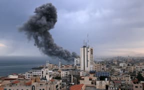 Smoke rises above buildings during an Israeli air strike, in Gaza City on October 9, 2023. Israeli troops fought to regain control of the desert around the Gaza Strip and evacuate people from the embattled border area on October 9, 2023, as the death toll from the war with Hamas surged above 1,100 by the third day of clashes. (Photo by MAHMUD HAMS / AFP)