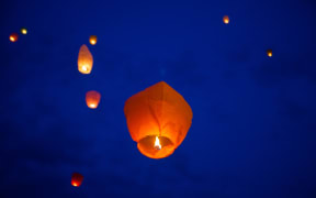 The Chinese lantern flies up highly in the sky. Background.