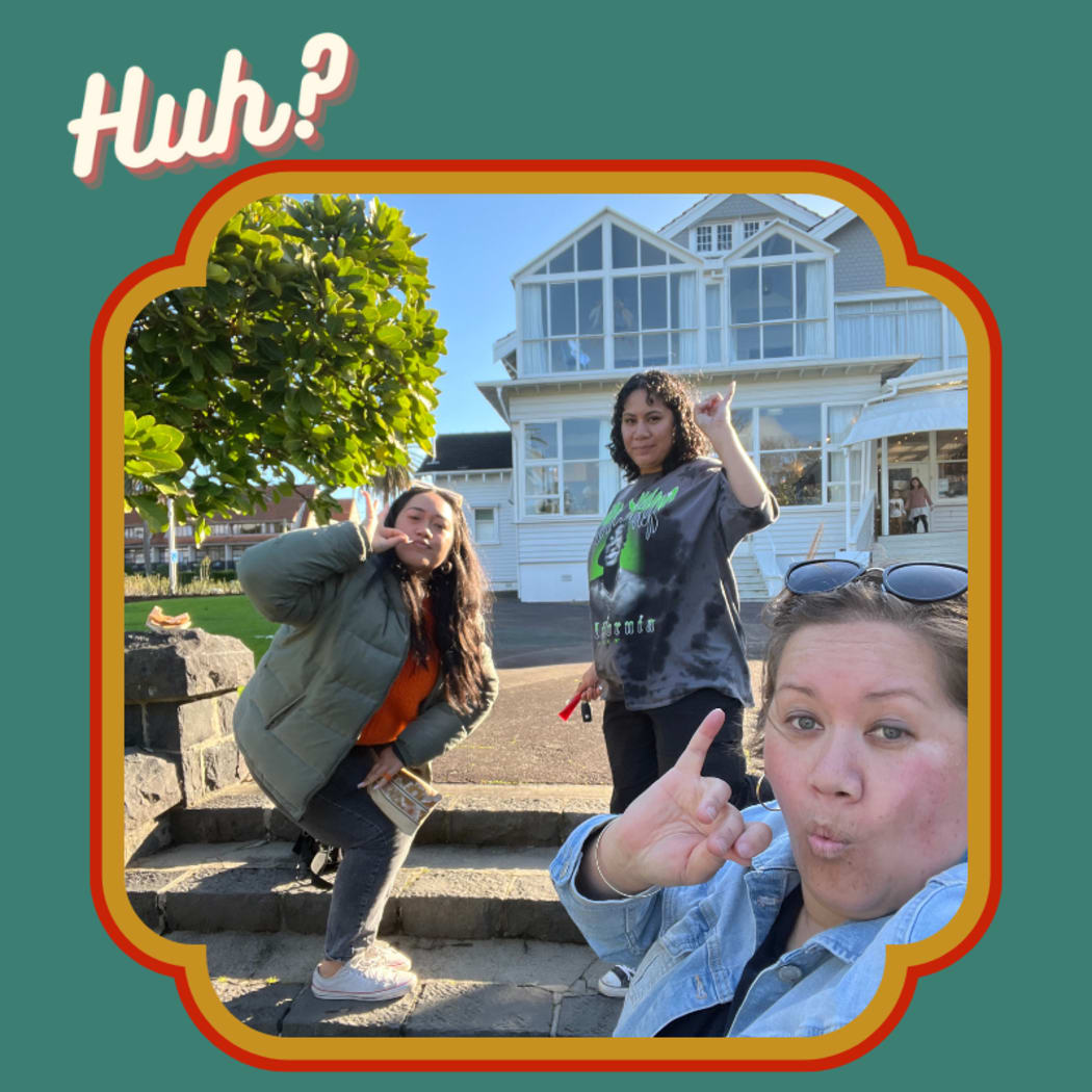 Three young women. the two hosts of the podcast, and their guest, an actor and comedian pose in front of a restaurant where they have been taking 'high tea'.