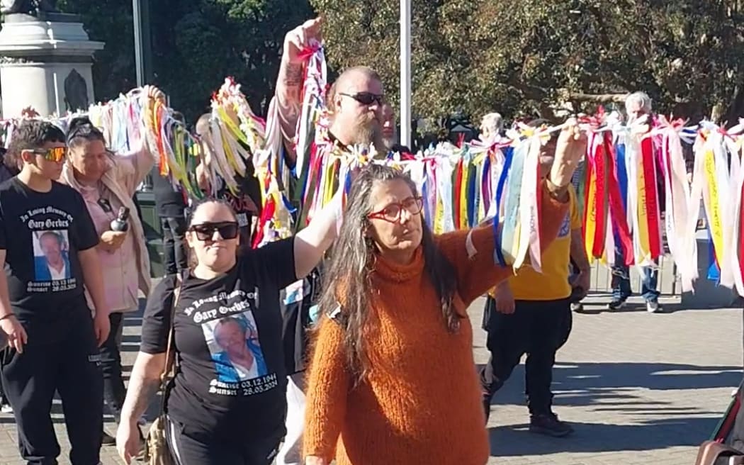 Ribbons bearing the names of mōrehu / survivors abused in state care are carried into Parliament