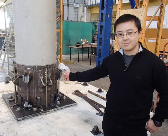 Canterbury University engineering student Royce Liu points to the dissipaters, which act like fuses and join the pier to the foundation block.