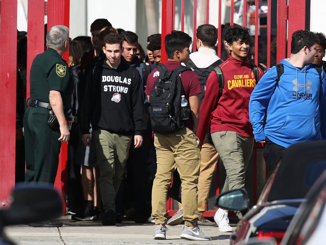 Students from Marjory Stoneman Douglas High School walk out of school to honor the memories of 17 classmates and teachers that were killed during a mass shooting at the school on March 14, 2018 in Parkland, Florida.