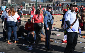 An injured person is helped near the Kansas City Chiefs' Super Bowl LVIII victory parade on February 14, 2024, in Kansas City, Missouri. Shots were reportedly fired during the parade, according to police. (Photo by ANDREW CABALLERO-REYNOLDS / AFP)