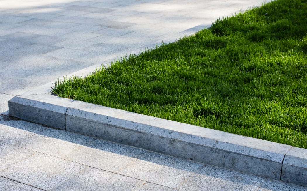 Green lawn on driveway, landscaping, berm.
