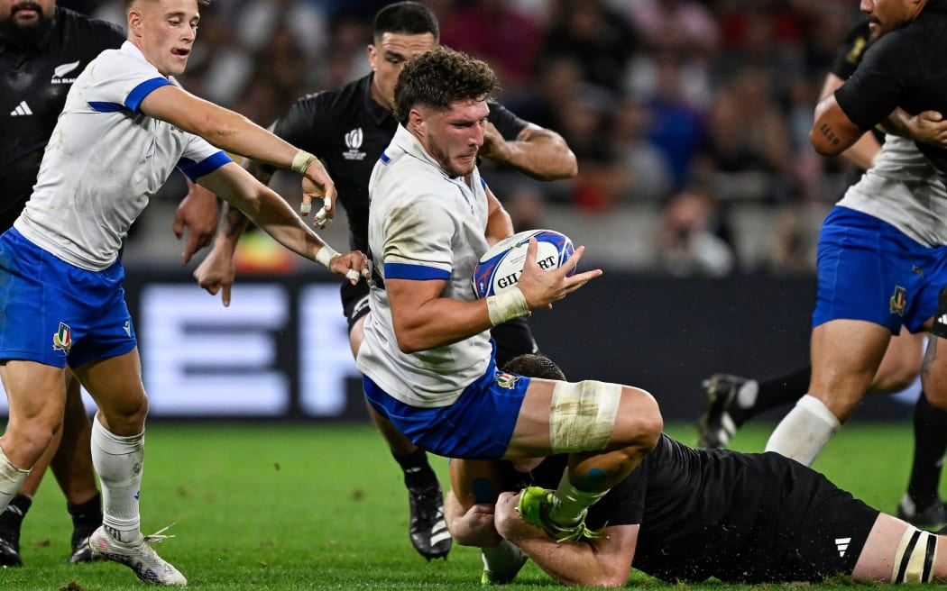 Dino Lamb of Italy is tackled by All Black Brodie Retallick during their Rugby World cup pool clash at Lyon.