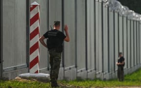 Polish border guards near the new fence on the Polish-Belarusian border near the village of Nowdziel. The border wall on the Polish-Belarusian border was built with the use of 50,000 tons of steel. It is 5.5 meters high,  topped with a razor wire and it stretches for 186.25 km. On Thursday, June 30, 2022, in Nowodziel, near Kuznica, Podlaskie Voivodeship, Poland.