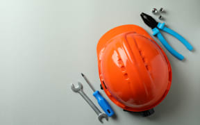 Hard hat and working tools on light gray background