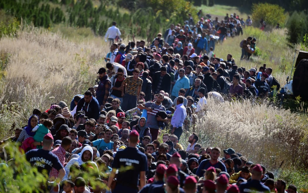 Refugees walk through the countryside after crossing the Hungarian-Croatian border, 21 Sept 2015.