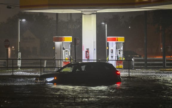 A vehicule is stranded on a water-flooded street after Hurricane Milton made landfall in Brandon, Florida on October 9, 2024. - Milton made landfall in Florida October 9, 2024 as an "extremely dangerous" Category 3 hurricane, packing life-threatening storm surge, extreme winds and flash flooding, the National Hurricane Center (NHC) said. "Data indicate the eye of Hurricane Milton has made landfall near Siesta Key in Sarasota County along the west coast of Florida," the NHC said in an 8:30 pm (0030 GMT Thursday) bulletin. (Photo by Miguel J. Rodriguez Carrillo / AFP)