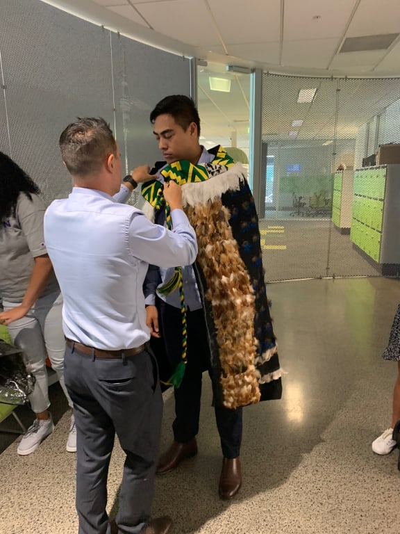 Dan Walker offering his whānau korowai to Dylan Apera at the welcoming of interns to Microsoft NZ.