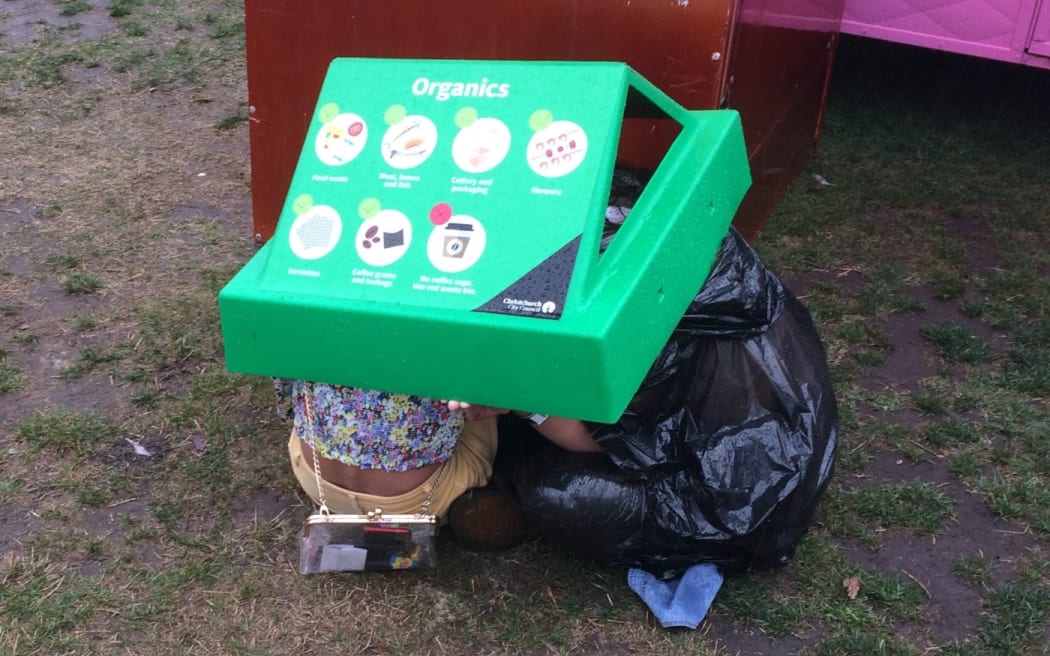 Punters at Christchurch's Electric Avenue shelter under a bin lid