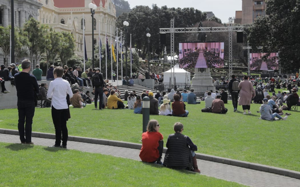 People gather at Parliament to watch the state memorial service for the late Queen.