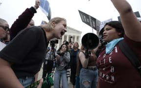 Pro-choice and anti-abortion activists yell at one another in front of the US Supreme Court building in Washington, DC on 3 May, 2022.