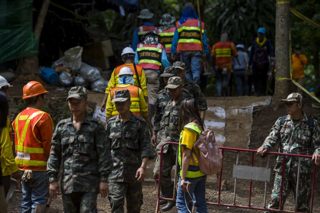 Thai soldiers and volunteers are seen at the entrance of Tham Luang cave.