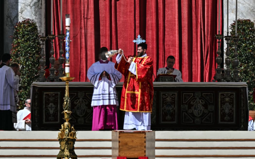 A member of the clergy swings a thurible of incense above the coffin of late Pope Francis during the funeral ceremony at St Peter's Square in the Vatican on April 26, 2025. (Photo by Andreas SOLARO / AFP)