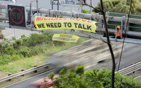Restore Passenger Rail protest on gantry on SH1 near Johnsonville