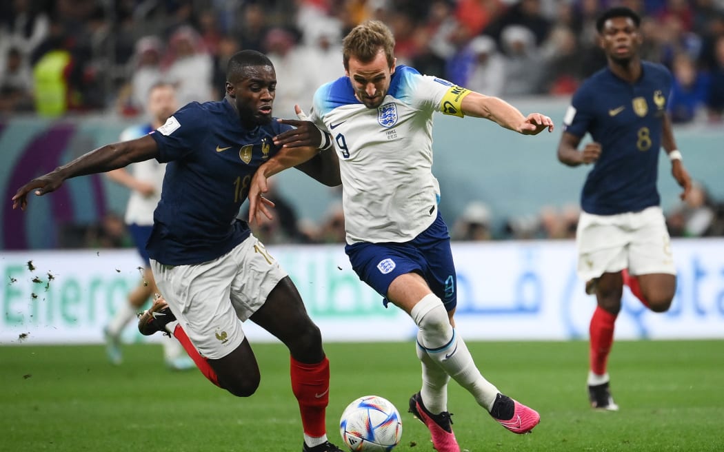 France's defender Dayot Upamecano (L) and England's forward Harry Kane fight for the ball during the Qatar 2022 World Cup quarter-final football match between England and France on December 10, 2022.