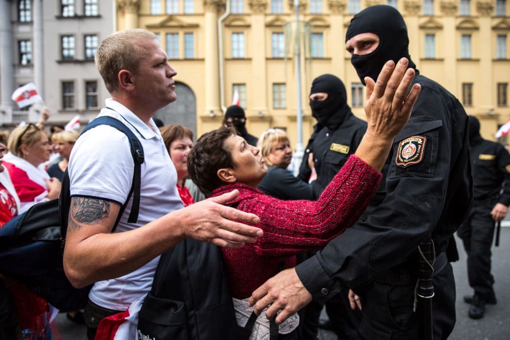 Protesters speak with Belarusian special police officers while opposition supporters rally to protest against disputed presidential elections results in Minsk on August 30, 2020
