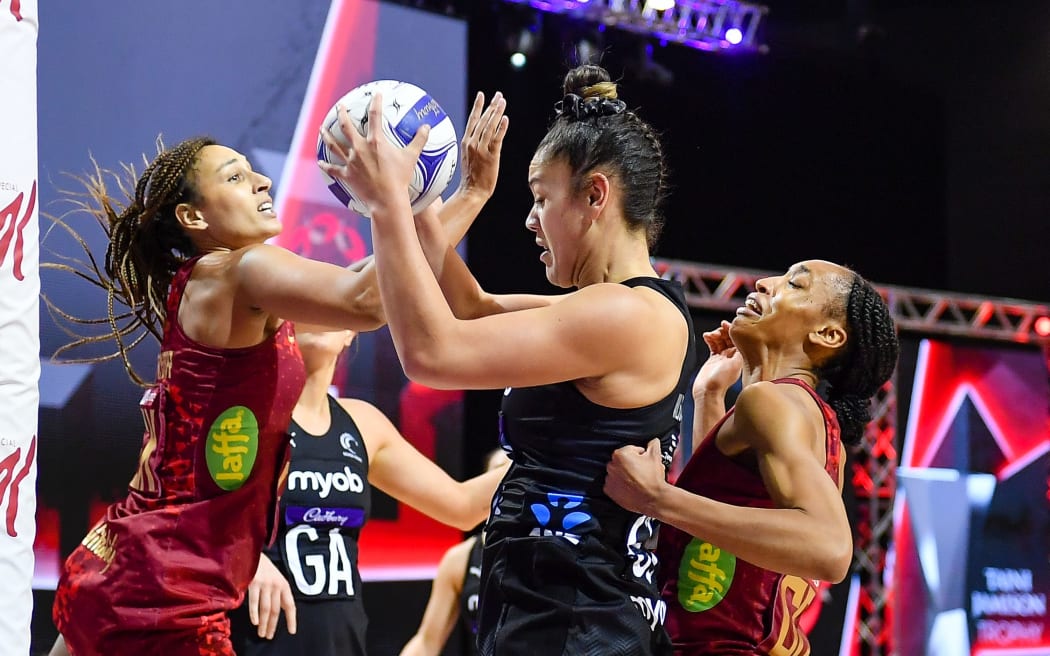 Maia Wilson of the Silver Ferns gets the ball from Geva Mentor of England and Layla Guscoth of England 2021.