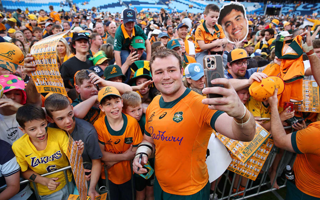Harry Wilson of the Wallabies takes a selfie with fans.