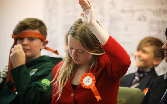 Prime Minister Ava calls to speak while still jotting notes for her pro-pineapple clarion call