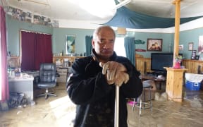 James Takarangi mops out his Waitotara home. Whanganui flood.