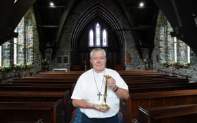 St Paul’s Anglican Church priest Chris Williams with the returned candlestick, dedicated to his grandfather Percy Williams.