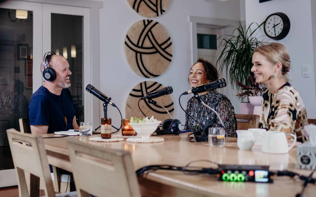 Reverend Frank Ritchie sits down at a dining table with Annabelle Lee-Mather and Mihingarangi Forbes.