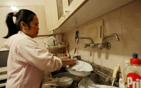 A house maid from Philippines washes the dishes at her employers' apartment in the Lebanese capital Beirut.