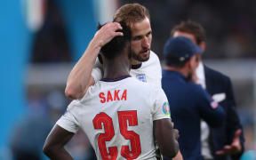 England's midfielder Bukayo Saka (L) is consoled by England's forward Harry Kane after their loss in the UEFA EURO 2020 final football match between Italy and England at the Wembley Stadium in London