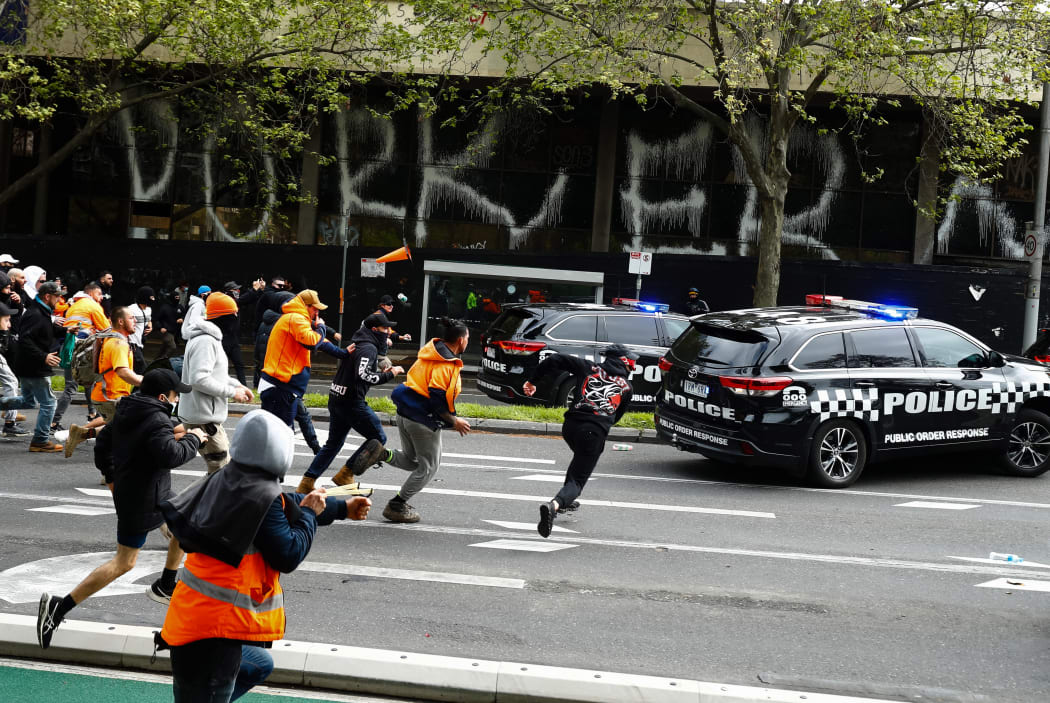Demonstrators hit a police car during a protest against Covid-19 regulations in Melbourne on September 21, 2021.