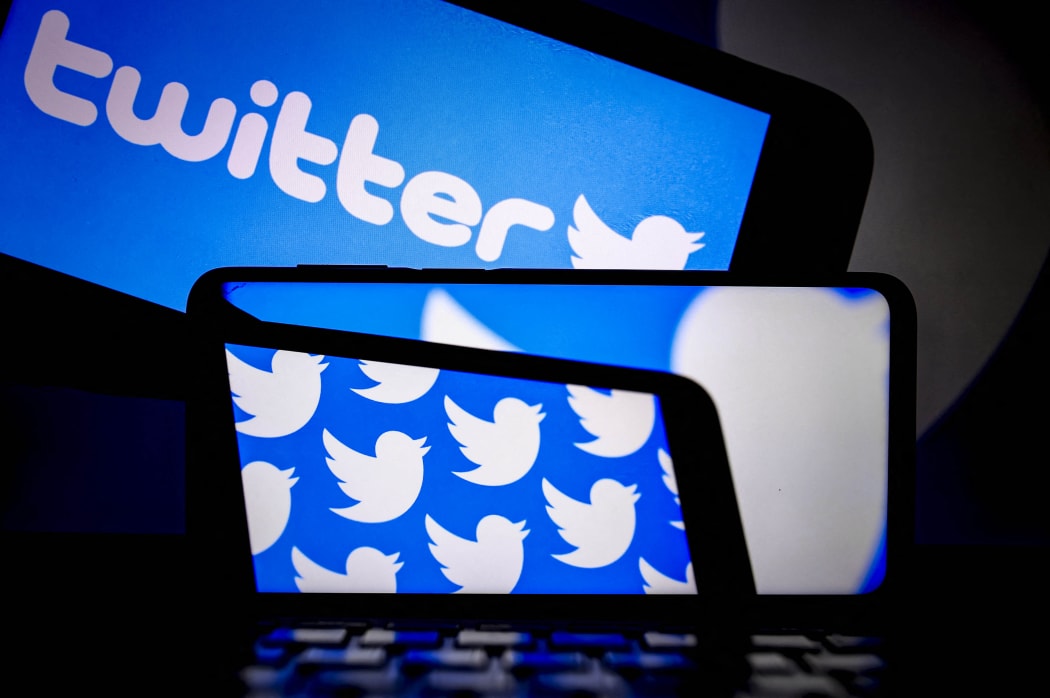 The logo of "twitter" is displayed on a smartphone and a screen in Ankara, Turkey on July 20, 2021.