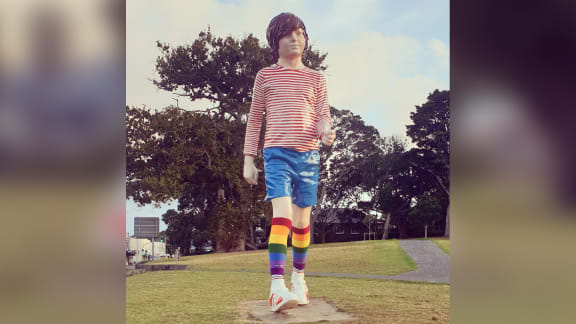 A large statue of a child wearing rainbow socks.