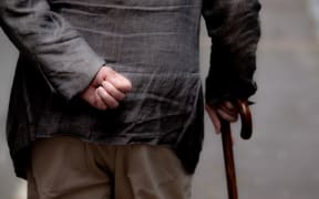 Elderly man walks on a street in Auckland.