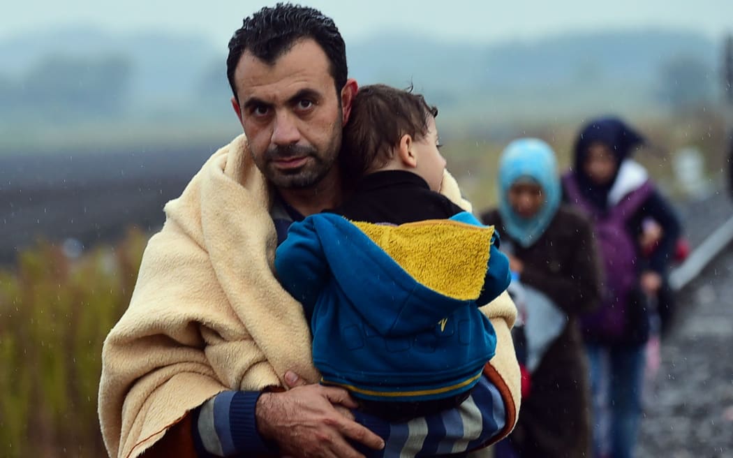 A migrant family arrives in Hungary in rainy weather at the Hungarian-Serbian border near Roszke on September 10, 2015.