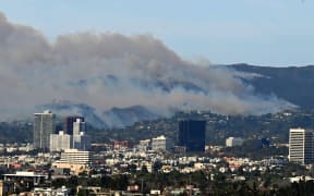 The Palisades fire burns as seen from Baldwin Hills Scenic Overlook in Los Angeles on January 8, 2025. - A ferocious wildfire in a Los Angeles suburb devoured buildings and sparked panicked evacuations January 7, as hurricane-force winds tore through the region. More than 200 acres (80 hectares) was burning in Pacific Palisades, a upscale spot with multi-million dollar homes in the Santa Monica Mountains. Across town, on the northern edge of Los Angeles, another fire broke out in Eaton Canyon, near Pasadena, quickly consuming 200 acres (81 hectares) later in the night, according to Angeles National Forest officials. (Photo by Agustin PAULLIER / AFP)