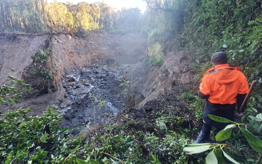 A DOC ranger checks out the damage to the Around the Mountain Circuit on Taranaki Maunga.