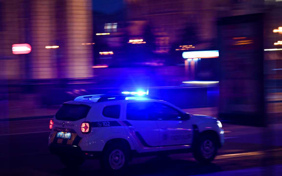 A police car drives on a street in central Kyiv early on February 24, 2022