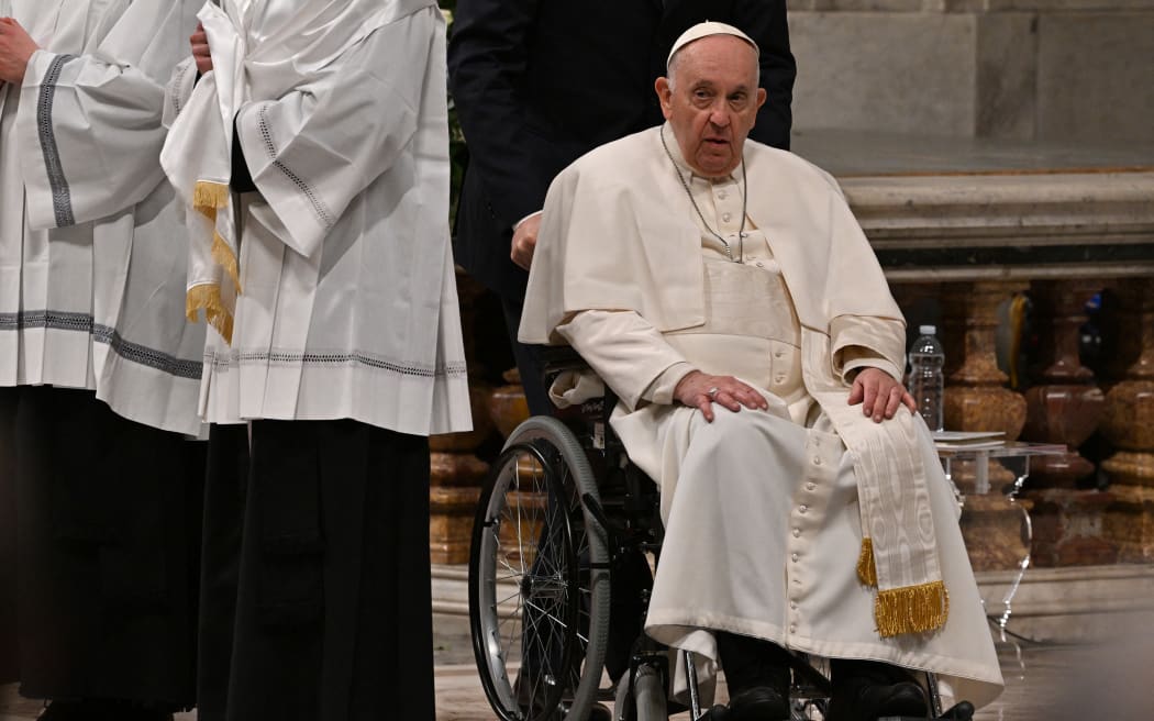 Pope Francis, seated in a wheelchair, leaves after leading the Easter Vigil mass on 8 April, 2023 at St. Peter's basilica in The Vatican, as part of celebrations of the Holy Week.