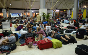 Foreign tourists sleep on the floor as they wait to depart from the Praya Lombok International Airport as aftershocks continue to rock Indonesia.