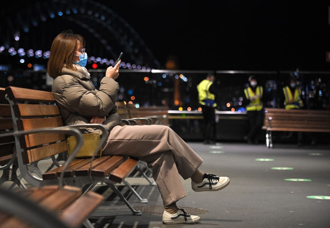 A woman waits for a ferry at Circular Quay near Sydney Harbour Bridge during lockdown in Sydney yesterday.