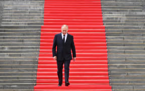 Russian President Vladimir Putin walks down the steps to address troops from the defence ministry, National Guard, FSB security service and interior ministry gathered on the Sobornaya (Cathedral) Square from the porch of the the Palace of the Facets on the grounds of the Kremlin in central Moscow on June 27, 2023. (Photo by Sergei GUNEYEV / SPUTNIK / AFP)